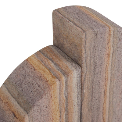Close-up of a stone or marble-look decorative block with layered beige, tan, and brown veining on a white background.