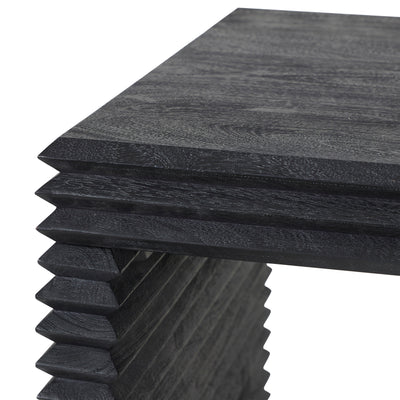 A black rectangular console table with a thick textured top and stacked, zigzag-style legs, shown against a plain white background.