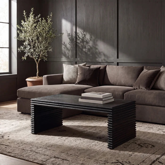 A black rectangular console table with a thick textured top and stacked, zigzag-style legs, shown against a plain white background.