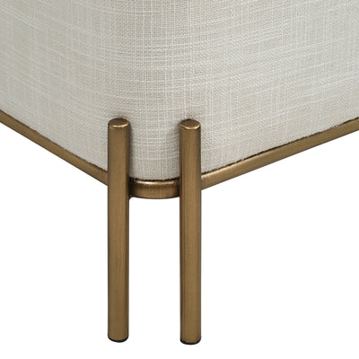 Close-up of a beige upholstered chair with gold metal legs on a white background